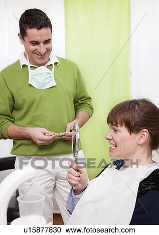 Stock Image - Patient examining teeth in surgery. Fotosearch