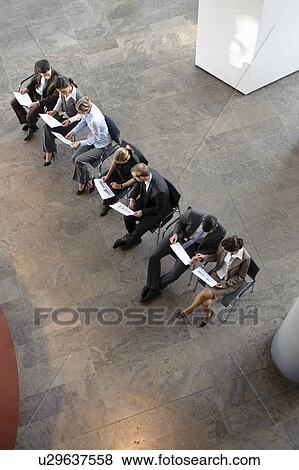 Stock Photo - People sitting working with papers. Fotosearch