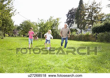 Stock Photo - Playing football with the grandparents. Fotosearch