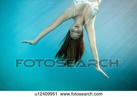 Stock Image - Portrait of girl upside down underwater. Fotosearch