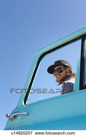 Stock Photo - Portrait of young man through car window. Fotosearch