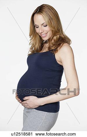 Pregnant woman holding belly View Large Photo Image Stock Image - Pregnant woman holding belly. Fotosearch