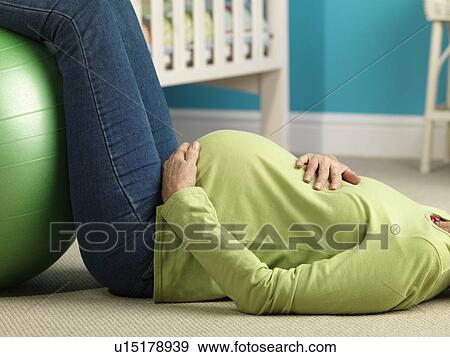 Pregnant woman lying on floor exercising View Large Photo Image Stock Photo - Pregnant woman lying on floor exercising. Fotosearch