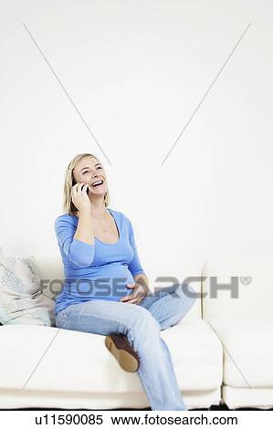 Stock Photography - Pregnant woman on phone. Fotosearch