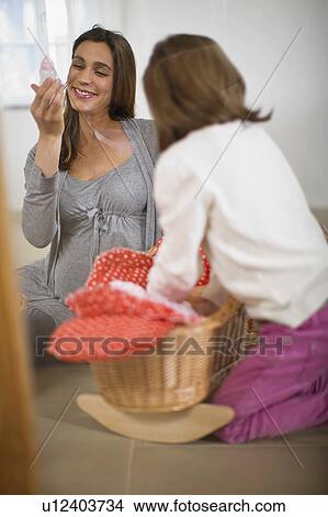 Picture - Pregnant woman playing with little girl. Fotosearch