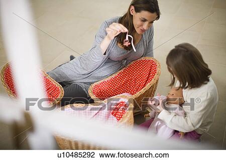 Stock Image - Pregnant woman playing with little girl. Fotosearch
