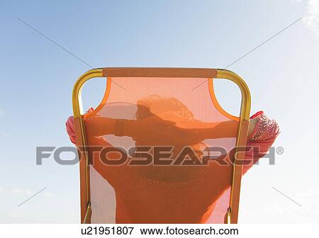 Stock Photo - Rear view of woman on deckchair. Fotosearch