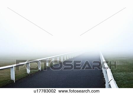 Stock Image - Road leading into fog. Fotosearch