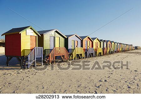 Stock Image - Row of colorful beach huts on beach. Fotosearch