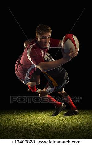 Stock Photo - Rugby player being tackled and scoring. Fotosearch