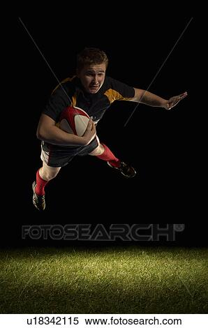Rugby player mid air with ball View Large Photo Image Stock Photography - Rugby player mid air with ball. Fotosearch