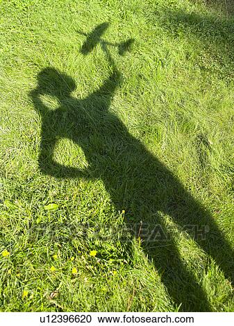 Shadow of a woman holding an rc plane View Large Photo Image Stock Image - Shadow of a woman holding an rc plane. Fotosearch