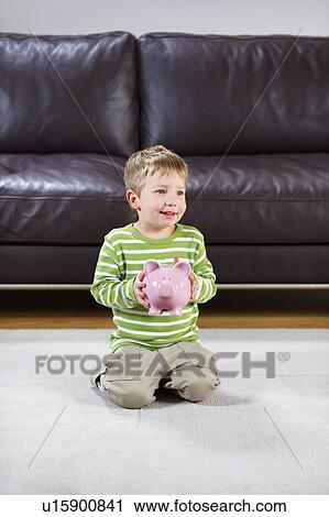 Smiling boy holding pink piggy-bank View Large Photo Image Stock Image - Smiling boy holding pink piggy-bank. Fotosearch