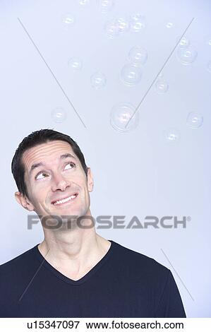 smiling man looking at bubbles View Large Photo Image Stock Photo - smiling man looking at bubbles . Fotosearch