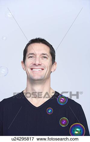 smiling man with soap bubbles around him View Large Photo Image Stock Photo - smiling man with soap bubbles around him. Fotosearch