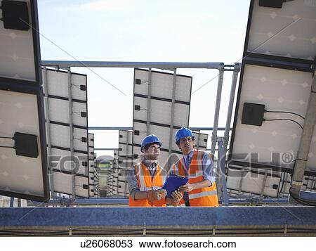 Stock Image - Spanish solar power station with workers. Fotosearch