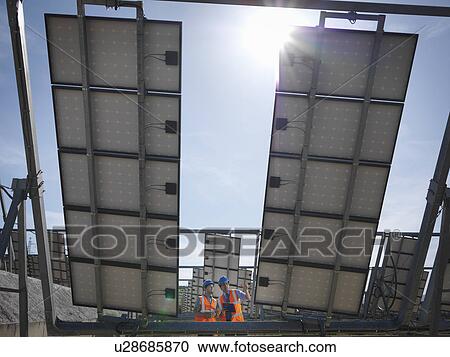 Stock Image - Spanish solar power station with workers. Fotosearch