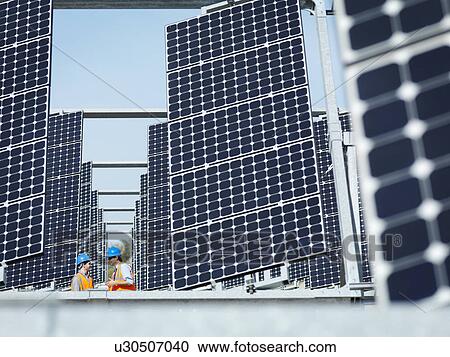 Stock Image - Spanish solar power station with workers. Fotosearch