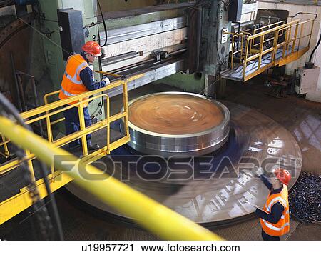 Stock Image - Steel Engineers Working With Lathe. Fotosearch
