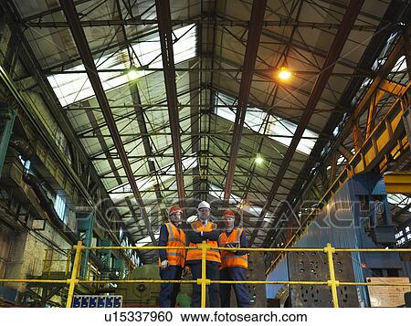 Stock Image - Steel Workers And Engineer In Factory. Fotosearch