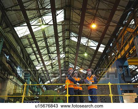 Stock Image - Steel Workers And Engineer In Factory. Fotosearch