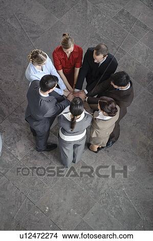 Picture - Team placing hands over each others. Fotosearch