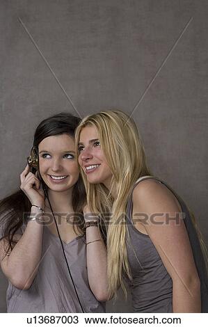 Stock Image - Teen girls with headphones. Fotosearch