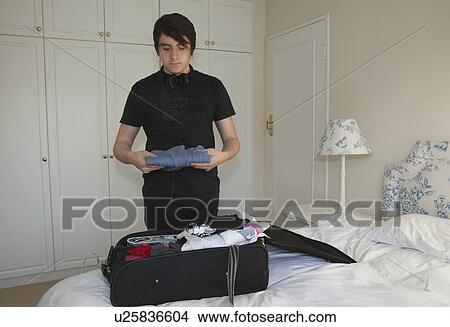 Teenage boy packing bag View Large Photo Image Picture - Teenage boy packing bag. Fotosearch