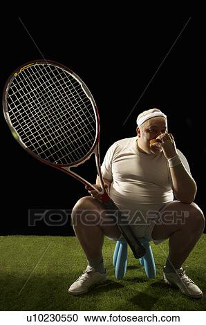Stock Image - Tennis player with large racquet sitting. Fotosearch