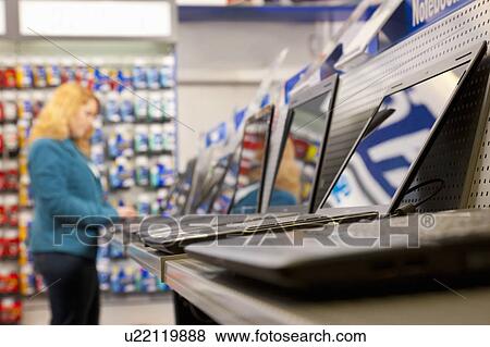 Stock Photo - Testing the shops' assortment of laptops. Fotosearch