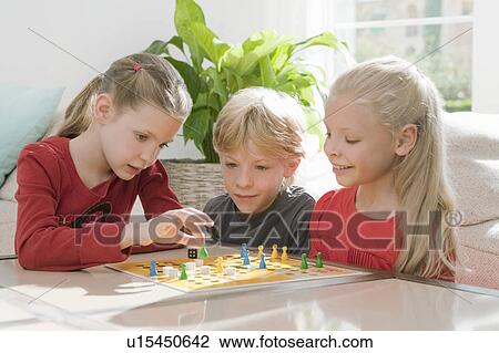 Three children playing a board game View Large Photo Image Stock Image - Three children playing a board game. Fotosearch