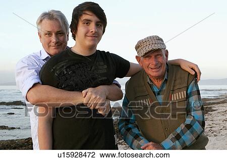 Stock Image - Three generations of men on beach. Fotosearch
