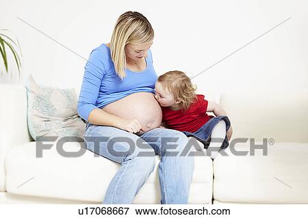 Toddler kissing pregnant belly View Large Photo Image Stock Photo - Toddler kissing pregnant belly. Fotosearch