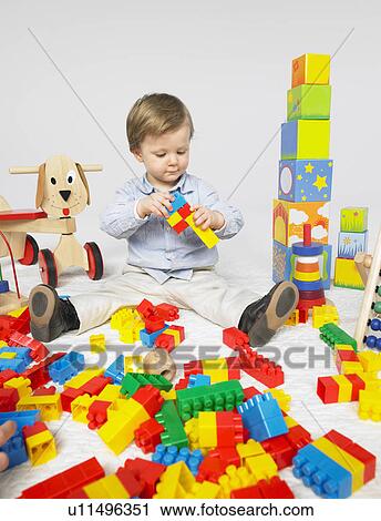 Stock Image - Toddler with many toys. Fotosearch