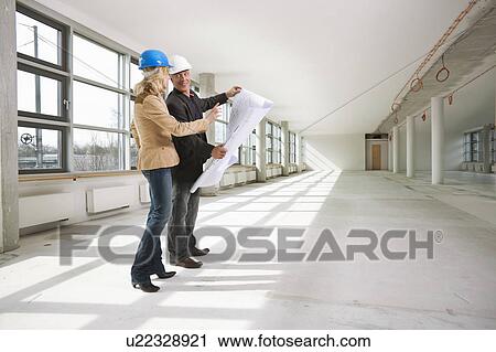 Two architects examining office building View Large Photo Image Stock Image - Two architects examining office building. Fotosearch