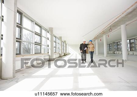 Two architects walking through site View Large Photo Image Stock Photo - Two architects walking through site. Fotosearch