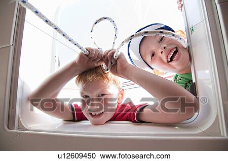 Two boys playing with hatch on yacht View Large Photo Image Stock Image - Two boys playing with hatch on yacht. Fotosearch
