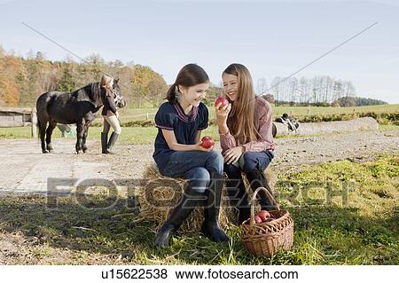 Stock Photo - Two girls eating and laughing. Fotosearch