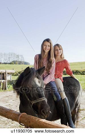 Two girls on horseback View Large Photo Image Stock Photography - Two girls on horseback. Fotosearch
