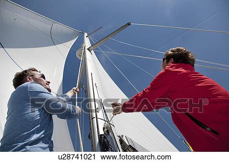 Two men pulling ropes on yacht View Large Photo Image Stock Image - Two men pulling ropes on yacht. Fotosearch