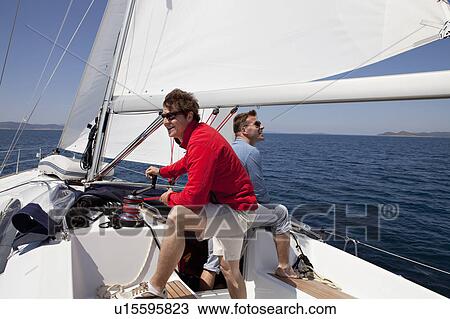 Two men setting sail on yacht View Large Photo Image Stock Image - Two men setting sail on yacht. Fotosearch