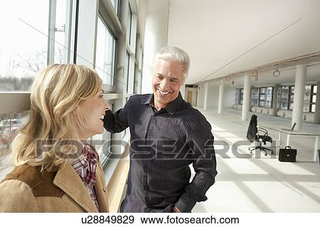 Two people standing in empty building View Large Photo Image Stock Photo - Two people standing in empty building. Fotosearch