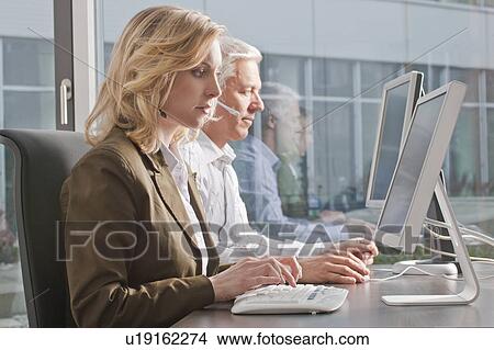 Two people working in a call center View Large Photo Image Picture - Two people working in a call center. Fotosearch