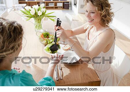 Two woman at table with mixed salad View Large Photo Image Stock Image - Two woman at table with mixed salad. Fotosearch