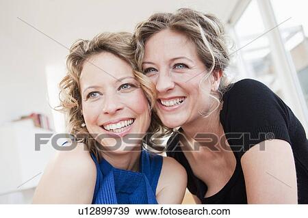Stock Photo - Two woman cheek to cheek smiling. Fotosearch