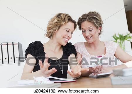 Stock Image - Two woman discussing business. Fotosearch
