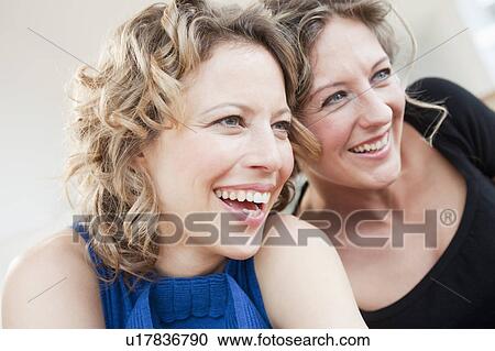Two woman laughing together View Large Photo Image Stock Image - Two woman laughing together. Fotosearch