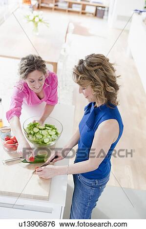 Two woman preparing salad in kitchen View Large Photo Image Stock Photograph - Two woman preparing salad in kitchen. Fotosearch
