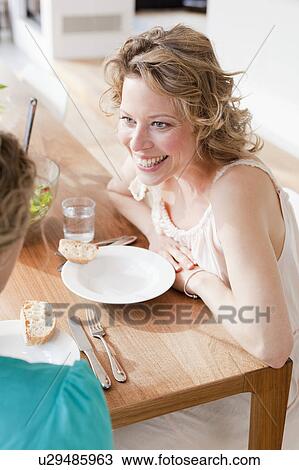 Two woman sitting at the table View Large Photo Image Stock Image - Two woman sitting at the table. Fotosearch