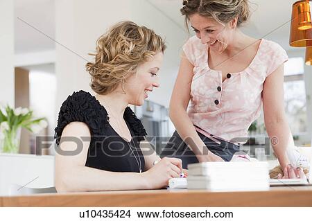 Picture - Two woman working together. Fotosearch